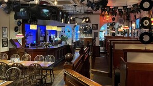 A bar area with wooden furniture, a counter, and a variety of hanging lights. - The White Hart Hotel (Holsworthy)