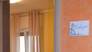 Habitación de hotel con cama, baño con cortina de ducha y un cartel en la pared.
