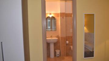 A bathroom with a sink, mirror, and toilet.