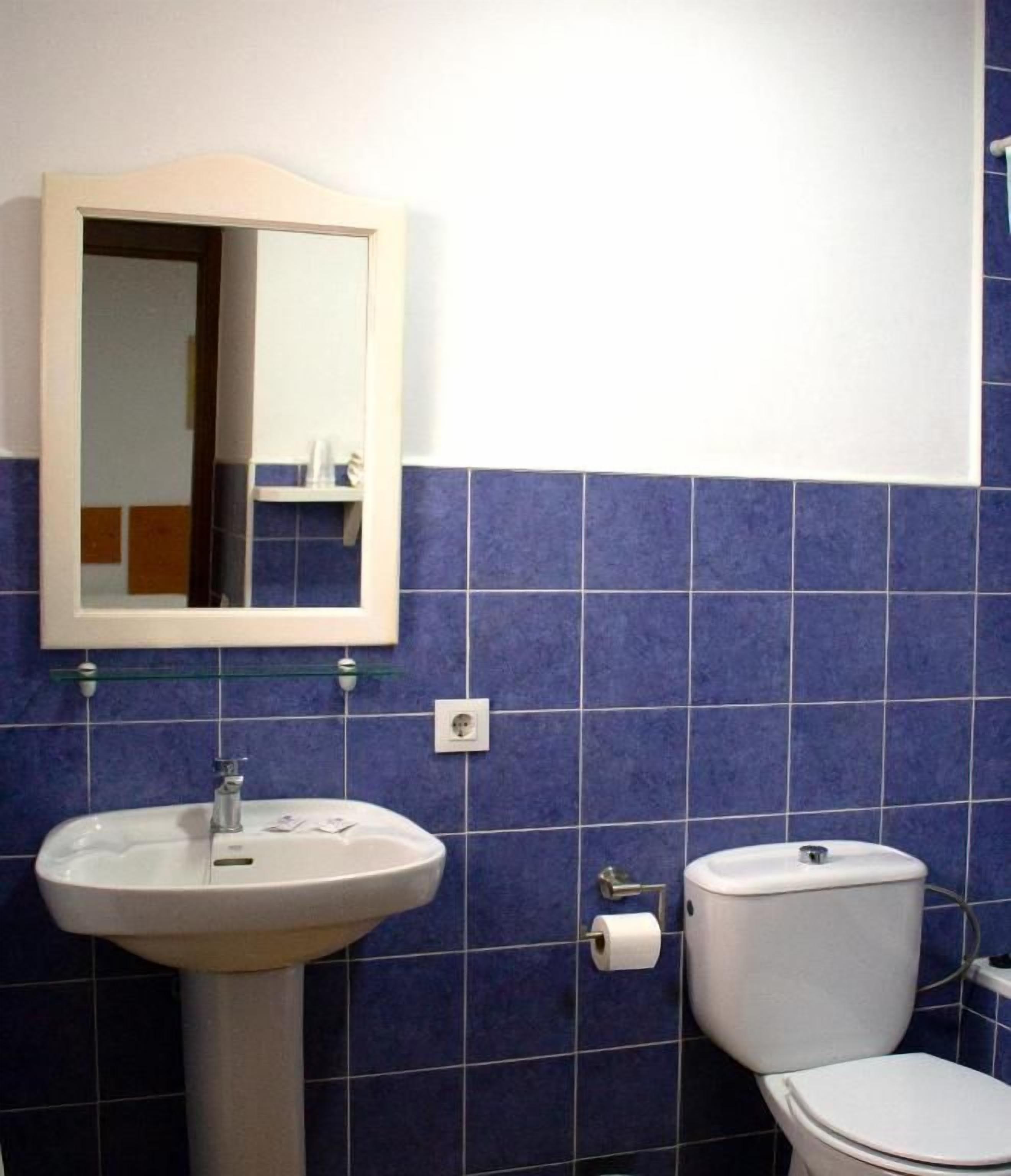 Ein Badezimmer mit Waschbecken, Spiegel und Toilette.