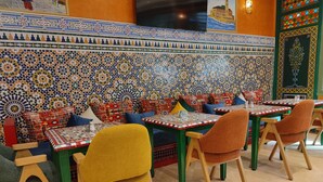 A restaurant interior with patterned tile walls, colorful seating, and a television screen. - Hotel Maamoura (Casablanca)