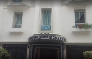 Een hotelentree met een bord waarop 'HOTEL' staat en decoratieve sterren erboven.