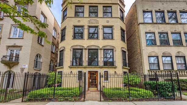 A multi-story building with a brick facade, multiple windows, and a gated entrance. - Vintage charm with open concept floor plan, great for entertaining and families. (Chicago)