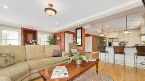A spacious living room with a sofa, coffee table, and a dining area with chairs. - Vintage charm with open concept floor plan, great for entertaining and families. (Chicago)