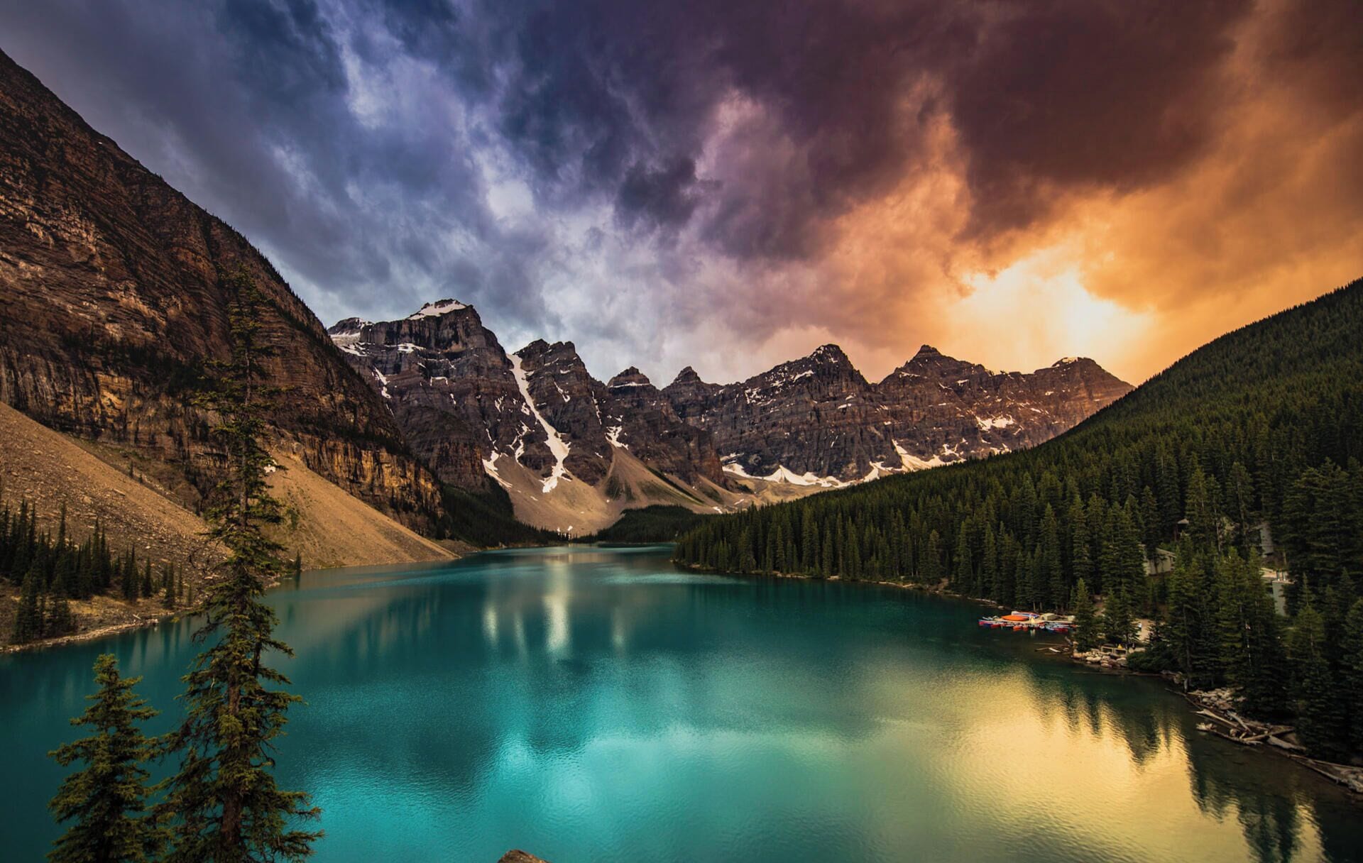 A mountain lake with reflections, surrounded by forested slopes and a clear sky.