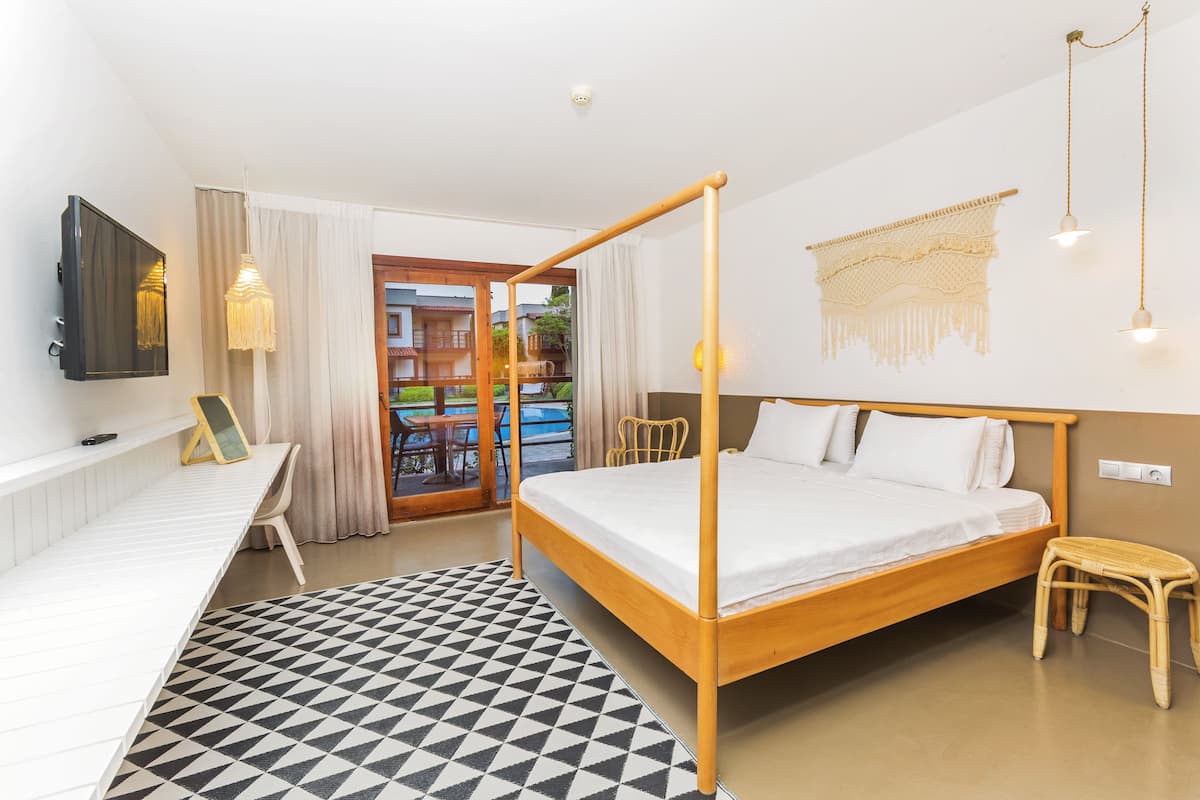 Deluxe Room, 1 King Bed, Balcony, Pool View | Minibar, in-room safe, desk, laptop workspace
