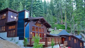 Eine Holzhütte mit mehreren Fenstern und einer Terrasse mit Stühlen.