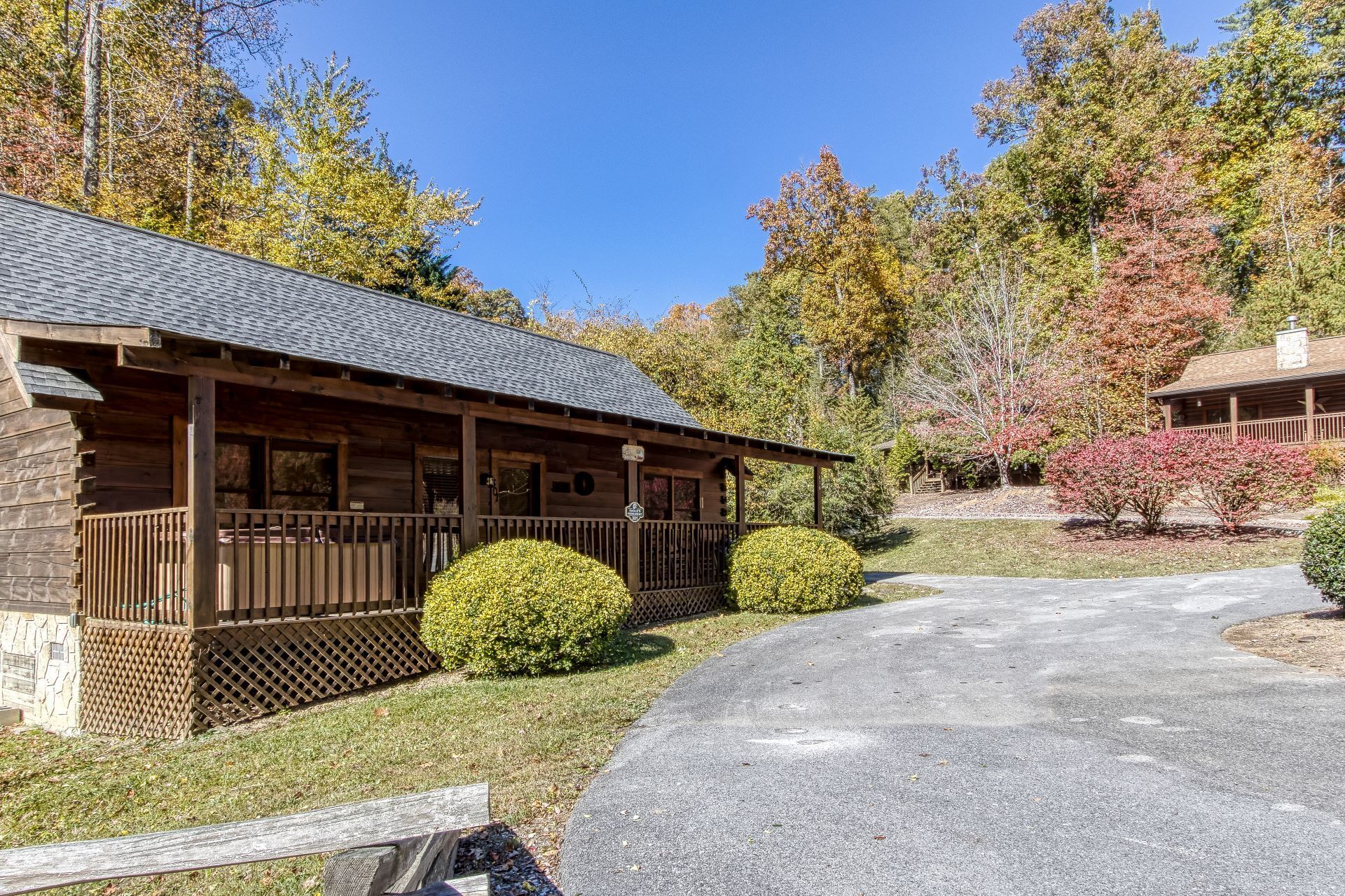 A rustic lodge with a covered porch and a gravel driveway.