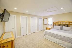 Cozy retreat with a large bed, television, and closet space.