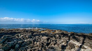Una costa rocosa con aguas azules cristalinas y un horizonte lejano.