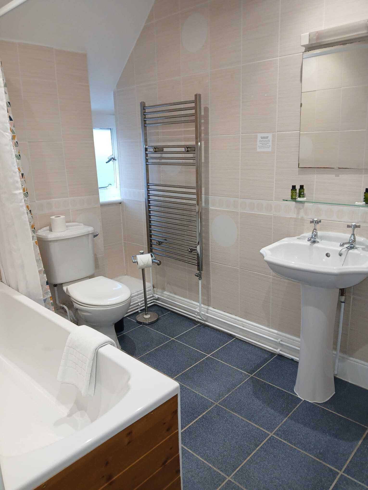 A bathroom with a bathtub, toilet, and sink.