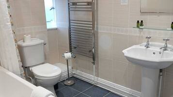A bathroom with a bathtub, toilet, and sink.