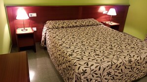 A hotel room with a bed, two bedside tables, and two wall-mounted lamps. - Hotel Don Pelayo (L'Arboc)