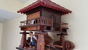 A wooden birdhouse with a balcony and a figure of a person. - Hotel Don Pelayo (L'Arboc)