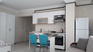 A compact living space with a kitchenette, a dining area with two chairs, a sofa, and a bed. - Dr.Aslan Apart Hotel - Airport (Cubuk)