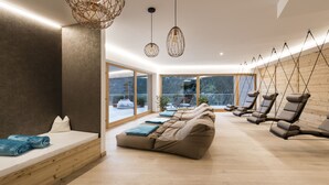 A modern spa room with a wooden floor, a large massage table, and several massage chairs. - Tuberis Nature & Spa Resort (Tubre)