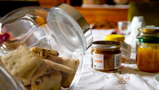 Un tarro de cristal con galletas sobre un mantel.