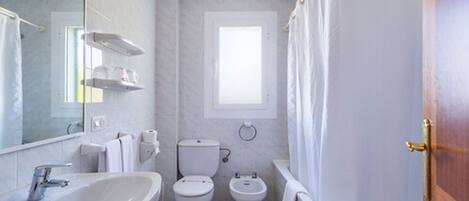 Un baño con lavamanos, inodoro, bidé y bañera.