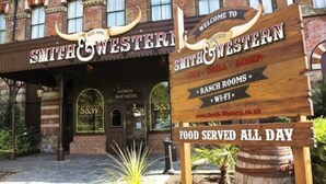 Ein Restaurant im Western-Stil mit einem Schild, auf dem 'Smith & Western' und 'Ganztägige Verpflegung' steht.