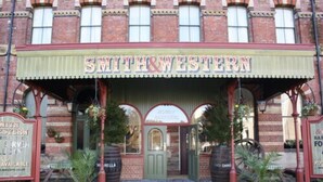 Ein Gebäude mit einem Schild über dem Eingang, auf dem „SMITH & WESTERN“ und „HONEY PARTRIERS“ stehen.