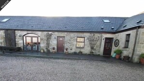 A stone building with a gravel driveway and a metal roof. - Tarrareoch Farm (Bathgate)