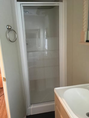 A bathroom with a shower, a toilet, and a sink. - Tarrareoch Farm (Bathgate)