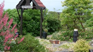 A garden entrance with a wooden pergola and a sign that reads "Entrance". - Tarrareoch Farm (Bathgate)