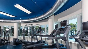 Un gimnasio moderno con cintas de correr, elípticas y máquinas de pesas.