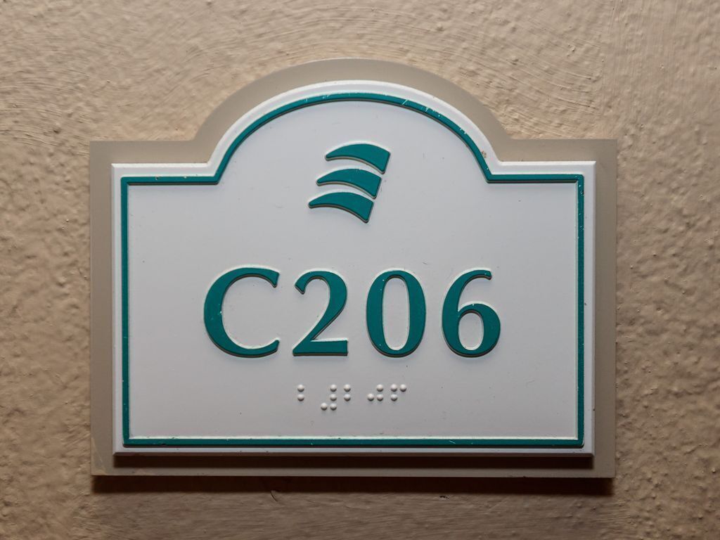 Un senyal amb el número C206 a una paret rugosa.