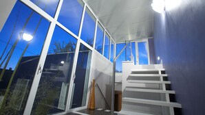 A modern interior with large windows, a staircase, and a view of the outside. - Hotel Intervallo (Porto Cesareo)