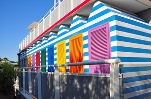 Un edificio con contraventanas coloridas y paredes a rayas.