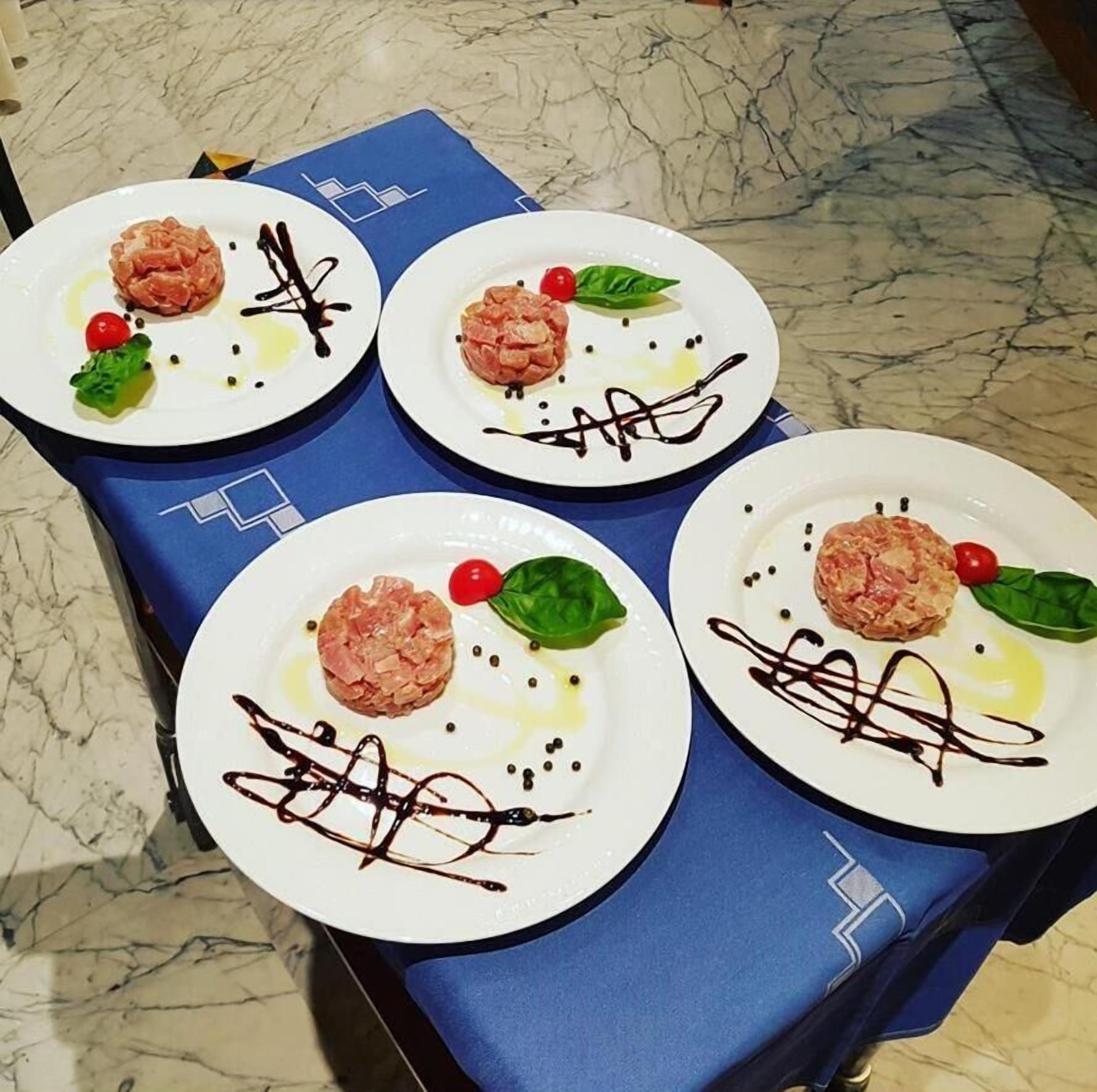 Four plates of food with a blue napkin underneath.