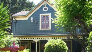 A two-story house with a porch, a decorative horse statue, and a Buddha statue. - HISTORIC VERY ROMANTIC 1883 SAN FRANCISCO CARRIAGE HOUSE (San Francisco)