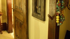 A wooden door with a decorative handle, a framed picture with a circular motif, and a colorful beaded necklace hanging on the wall. - HISTORIC VERY ROMANTIC 1883 SAN FRANCISCO CARRIAGE HOUSE (San Francisco)