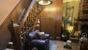 A cozy living room with a staircase, leather sofas, a fireplace, and a chandelier. - HISTORIC VERY ROMANTIC 1883 SAN FRANCISCO CARRIAGE HOUSE (San Francisco)