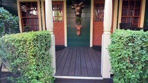 A porch with a bull head decoration, wooden steps, and green foliage. - HISTORIC VERY ROMANTIC 1883 SAN FRANCISCO CARRIAGE HOUSE (San Francisco)