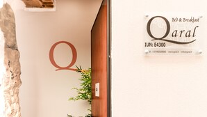 A hotel sign with a large 'Q' and the name 'Qaral' indicating a Bed & Breakfast establishment. - Qaral Bed and Breakfast (Cagliari)