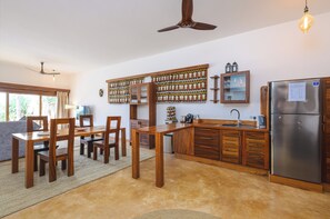 A modern kitchen with wooden cabinets, a built-in oven, and a refrigerator. - Zanzibar Sunrise at Bandas (Matemwe)