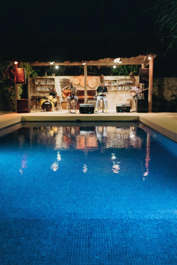 A swimming pool with a tiled edge, surrounded by a covered area with musical instruments and speakers. - Zanzibar Sunrise at Bandas (Matemwe)