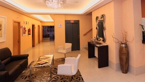 A hotel lobby with a reception desk, seating area, and a staircase. - Hotel HC Sigüenza (Siguenza)