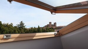 A skylight with a view of a historic castle and surrounding greenery. - Hotel HC Sigüenza (Siguenza)