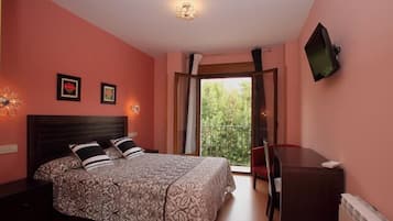 Een slaapkamer met een bed, bureau en televisie.