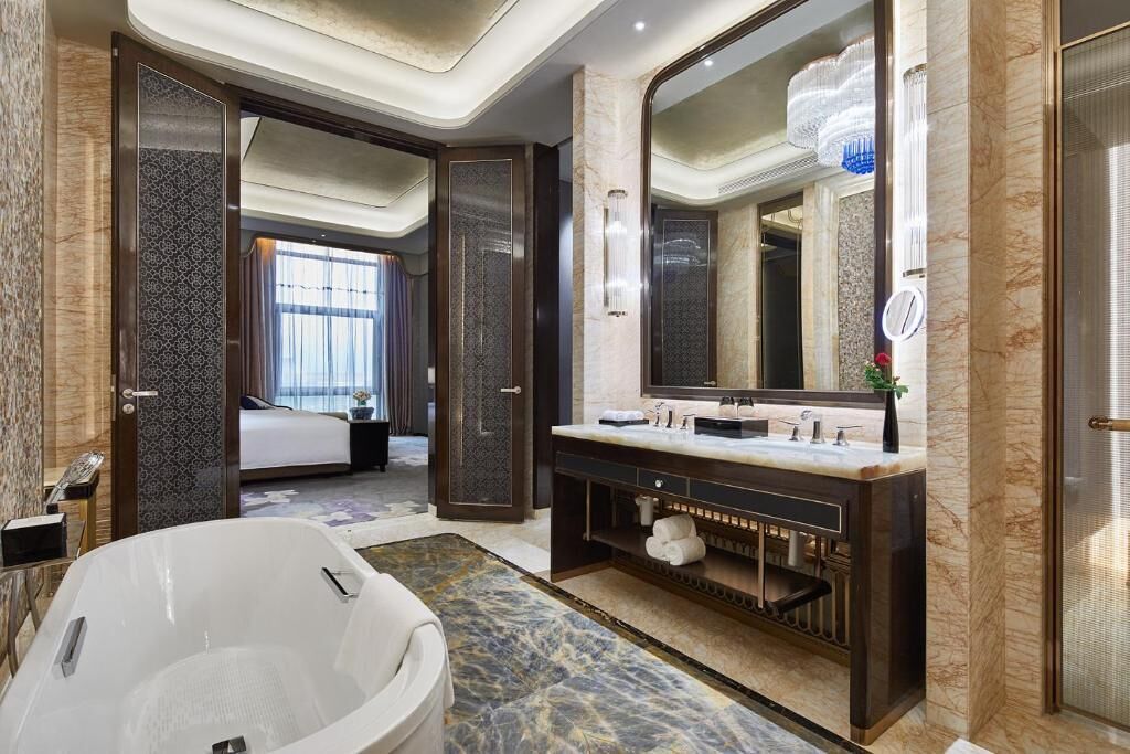 A modern bathroom with a freestanding bathtub, a large mirror, and a vanity with a double sink.