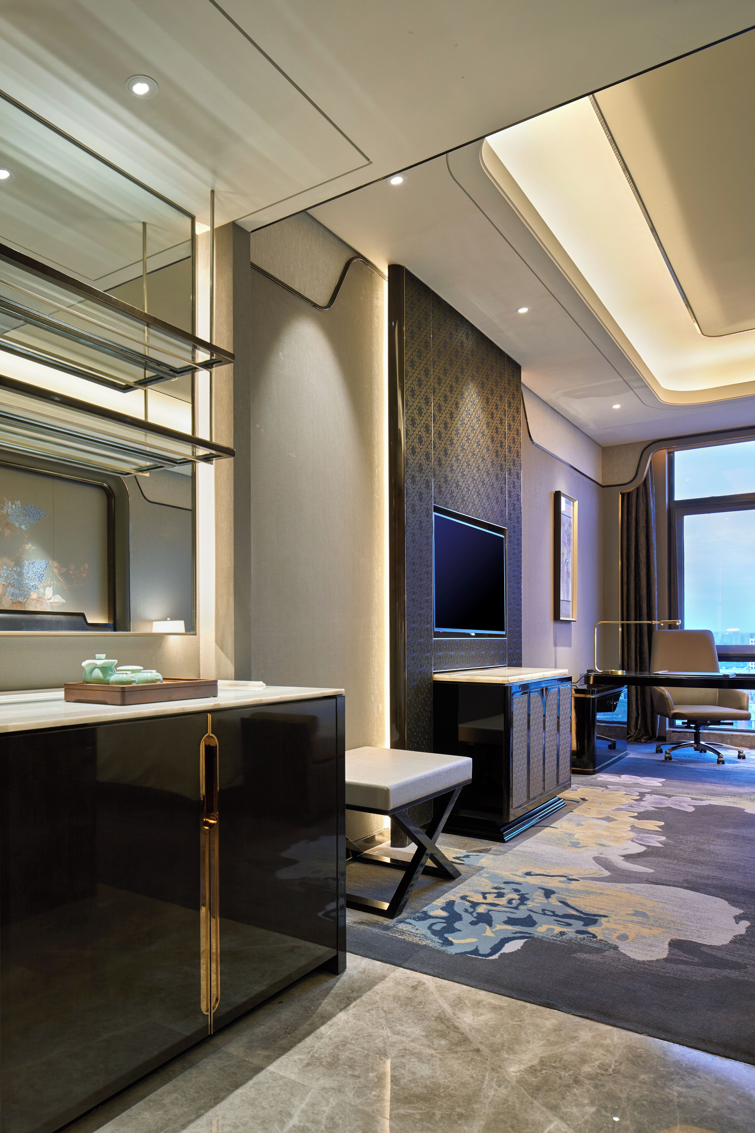 Une chambre d’hôtel moderne dotée d’une grande télévision à écran plat, d’un bureau et d’un coin salon confortable.