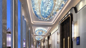 Ein luxuriöser Hotelkorridor mit einer prächtigen Kristallleuchtre, Marmorwänden und einem Teppichboden.