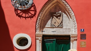 A red building with a green door, a round window, and a sign indicating the number 2. - Palace Divnic by Armerun Heritage Hotel (Sibenik)