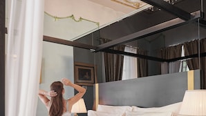 A bedroom with a large bed, a mirror, and a chandelier. - Palace Divnic by Armerun Heritage Hotel (Sibenik)