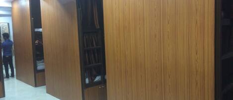 A hallway with wooden paneling and a person standing near a door.