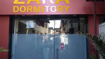 A dormitory building with a large sign reading "ZARA DORMITORY".