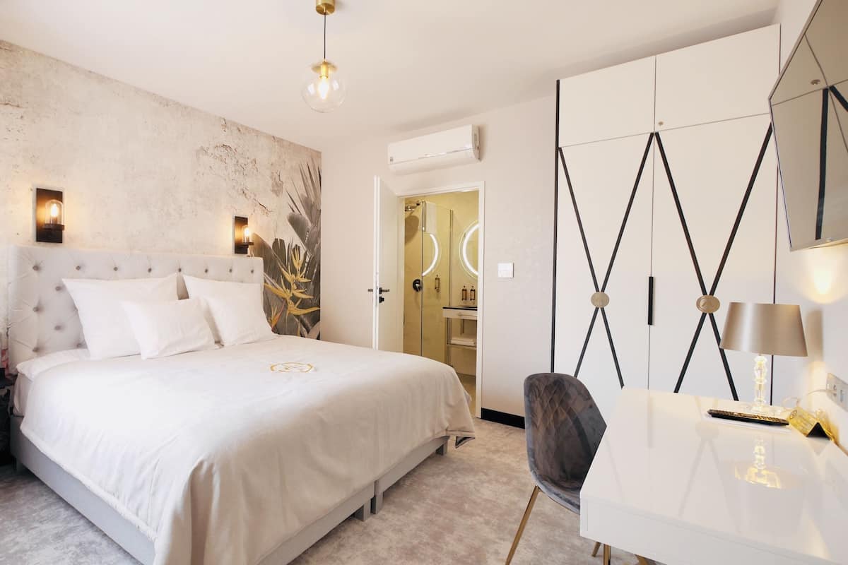 Un dormitorio moderno con una cama grande, un armario y un escritorio.